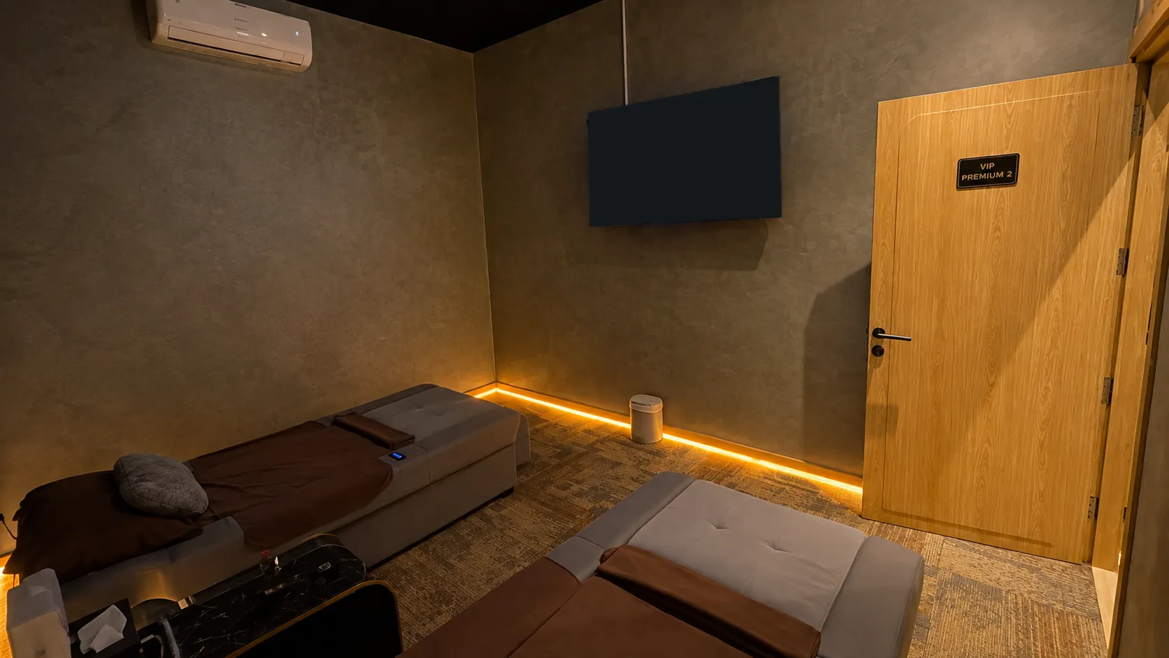 Ruang VIP Premium 2: dua bed perawatan dengan TV besar di dinding dan pintu bertanda VIP Premium 2
