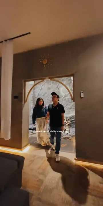Bernadus Handrico dan pasangannya masuk lewat gerbang lengkung di Senzu Reflexology