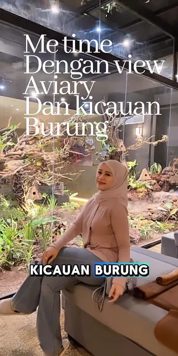Dinda Fitriani Yasmin duduk di tepi kaca taman aviary di Senzu Reflexology